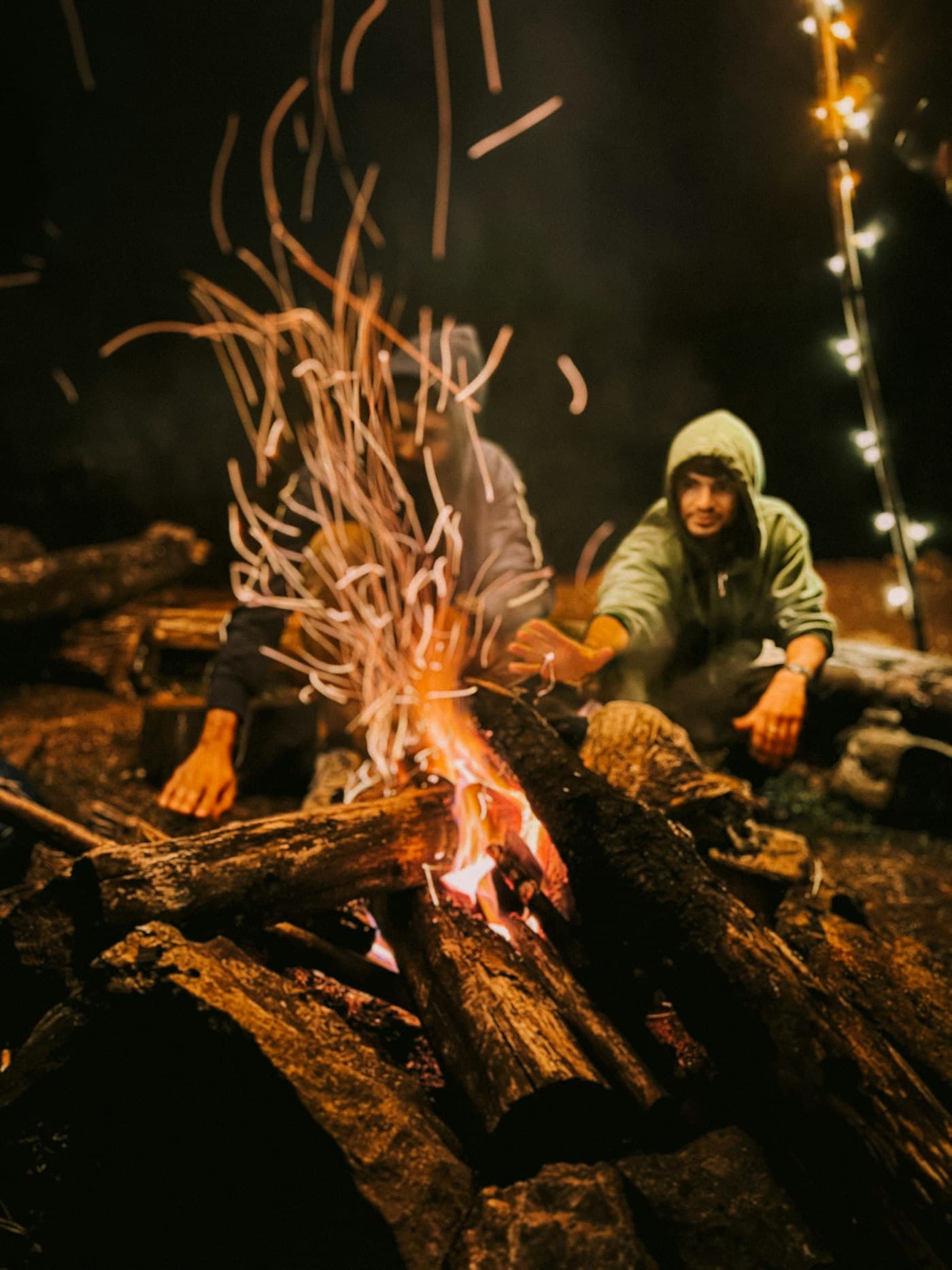 Two friends by a campfire at night