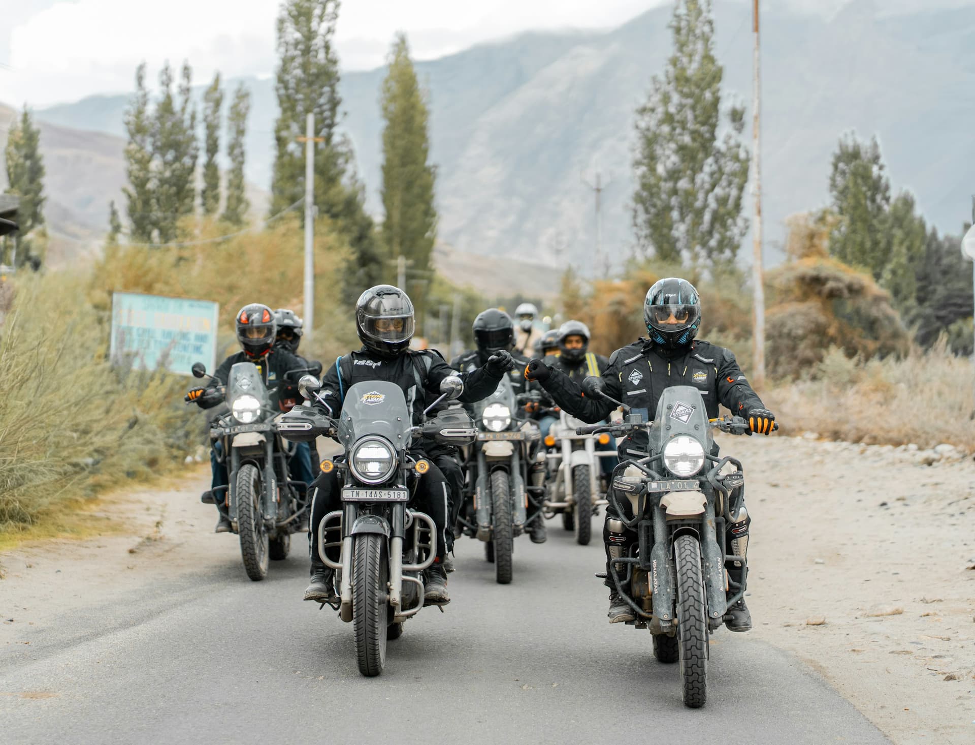 Riders on motorcycles on a poplar-lined mountain road